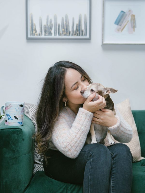 Laura on green couch kissing mila